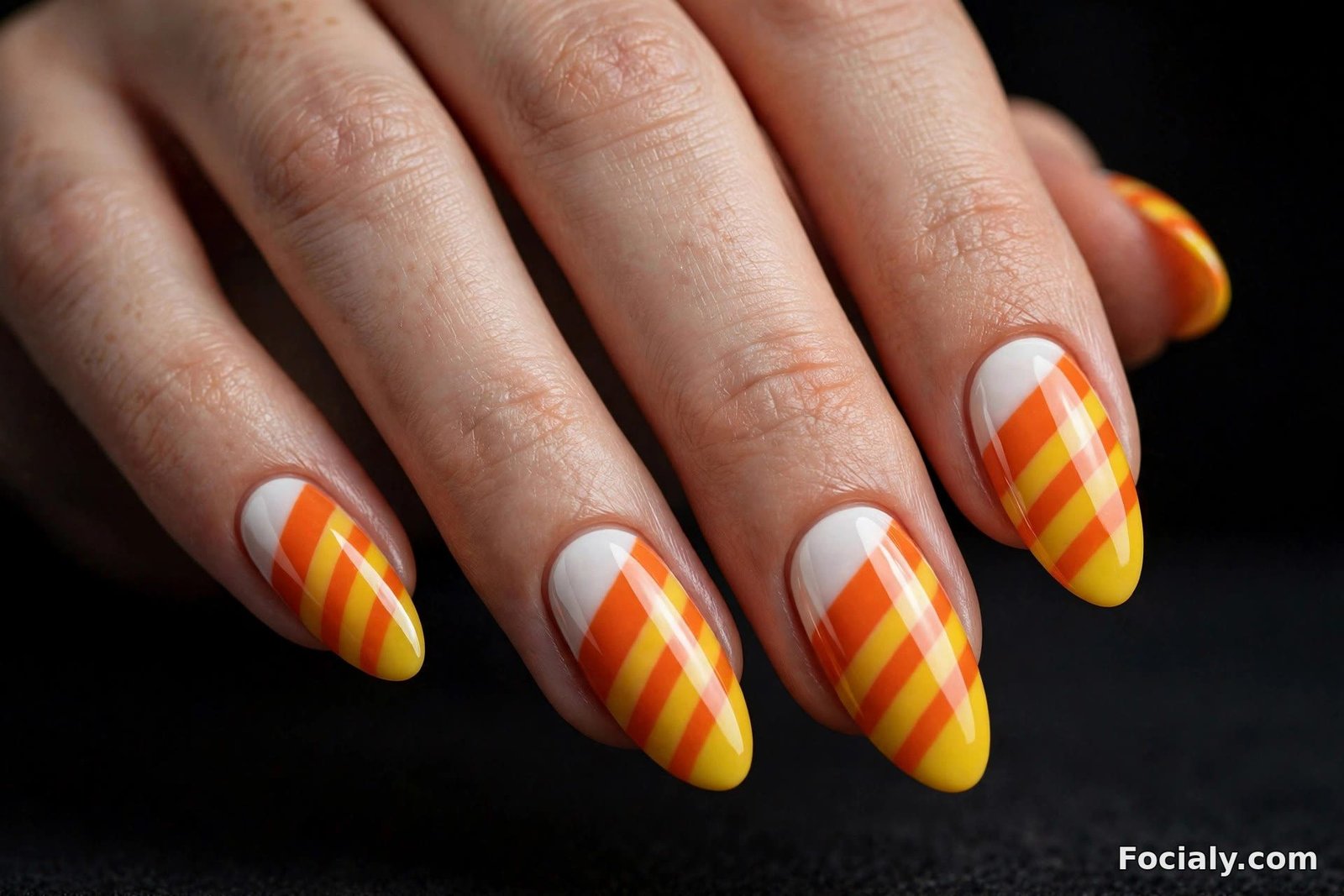 Candy corn striped Halloween nail art in white orange and yellow