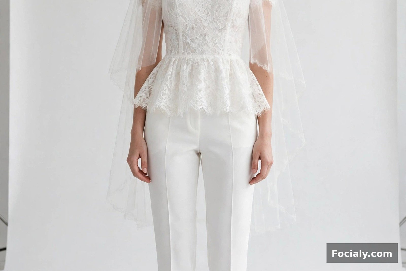 Bride in a white lace top and tailored white trousers