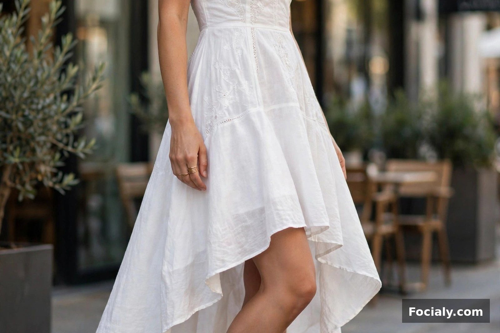 Woman in a white high-low hem dress showing off her shoes