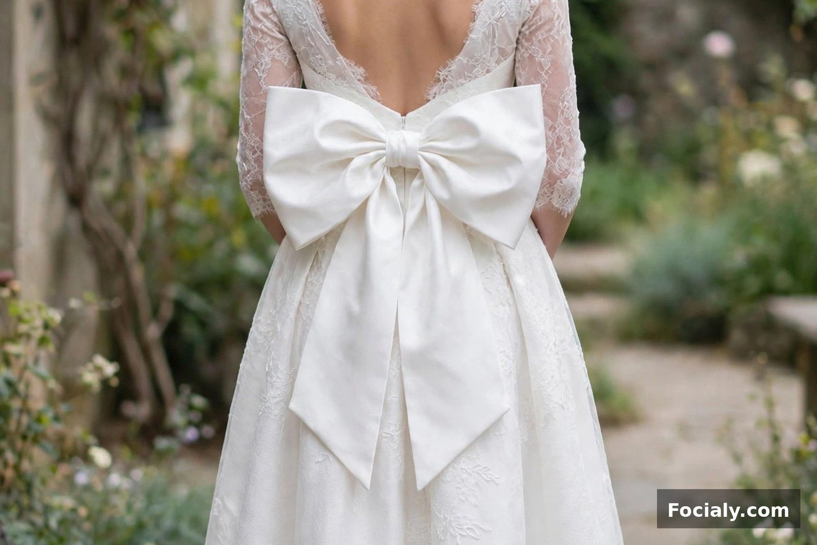 Bride in a white midi dress with a large bow at the back