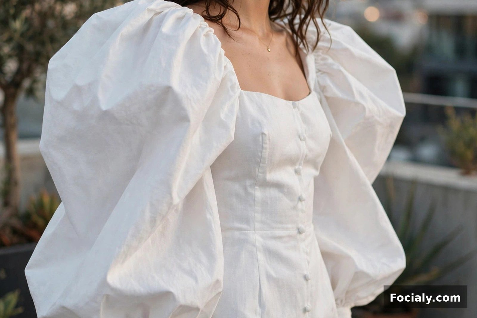 Woman in a white mini dress with dramatic bishop sleeves