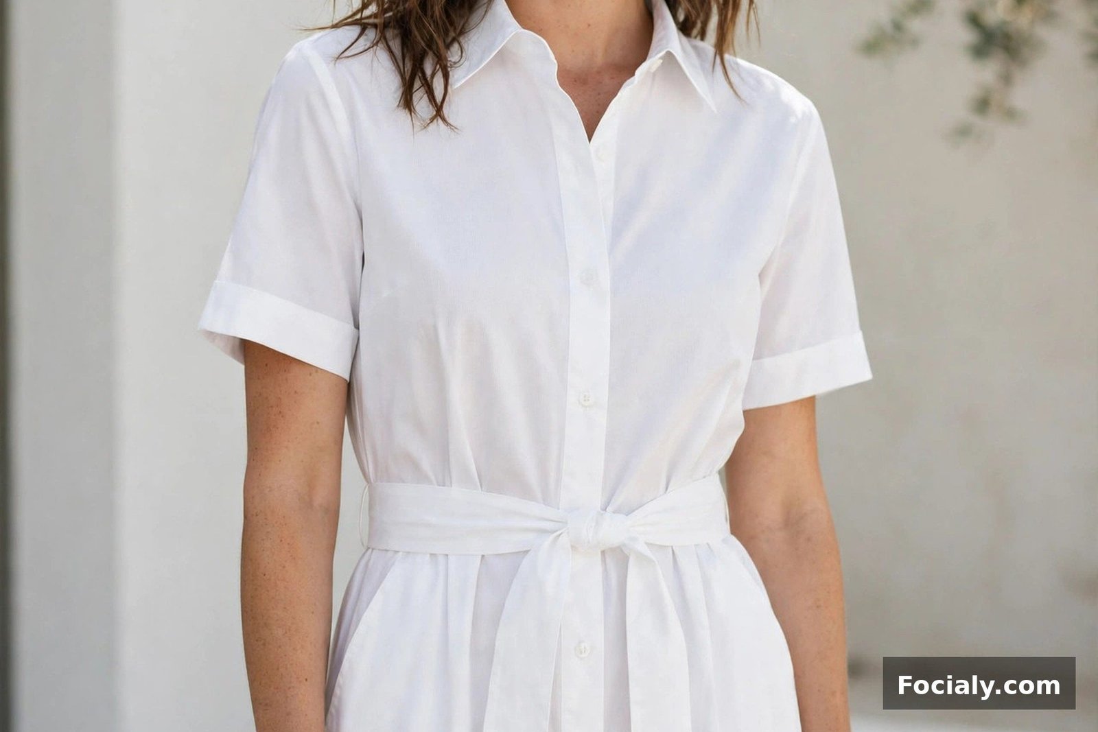 Woman in a crisp white poplin shirt dress with a belt