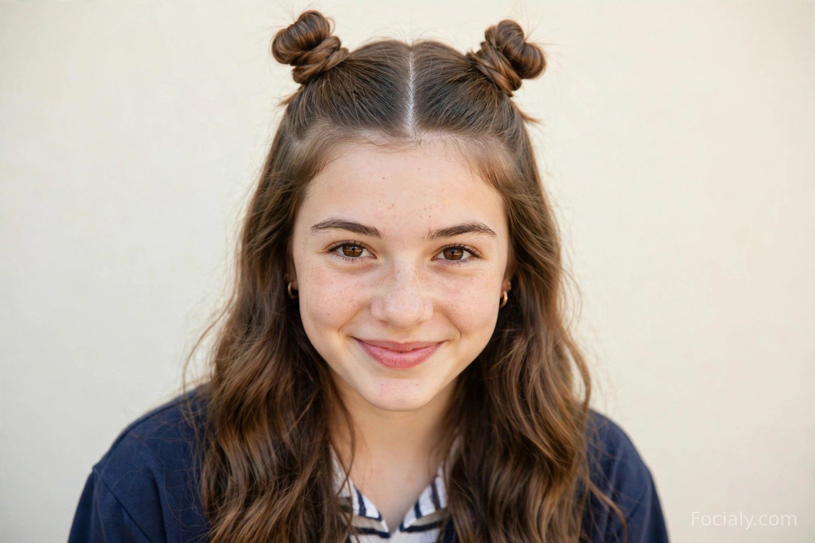 Two cute mini space buns on top of the head with the rest of the hair left loose and wavy
